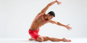 Person stretching, vibrant colors, dynamic pose, studio background.